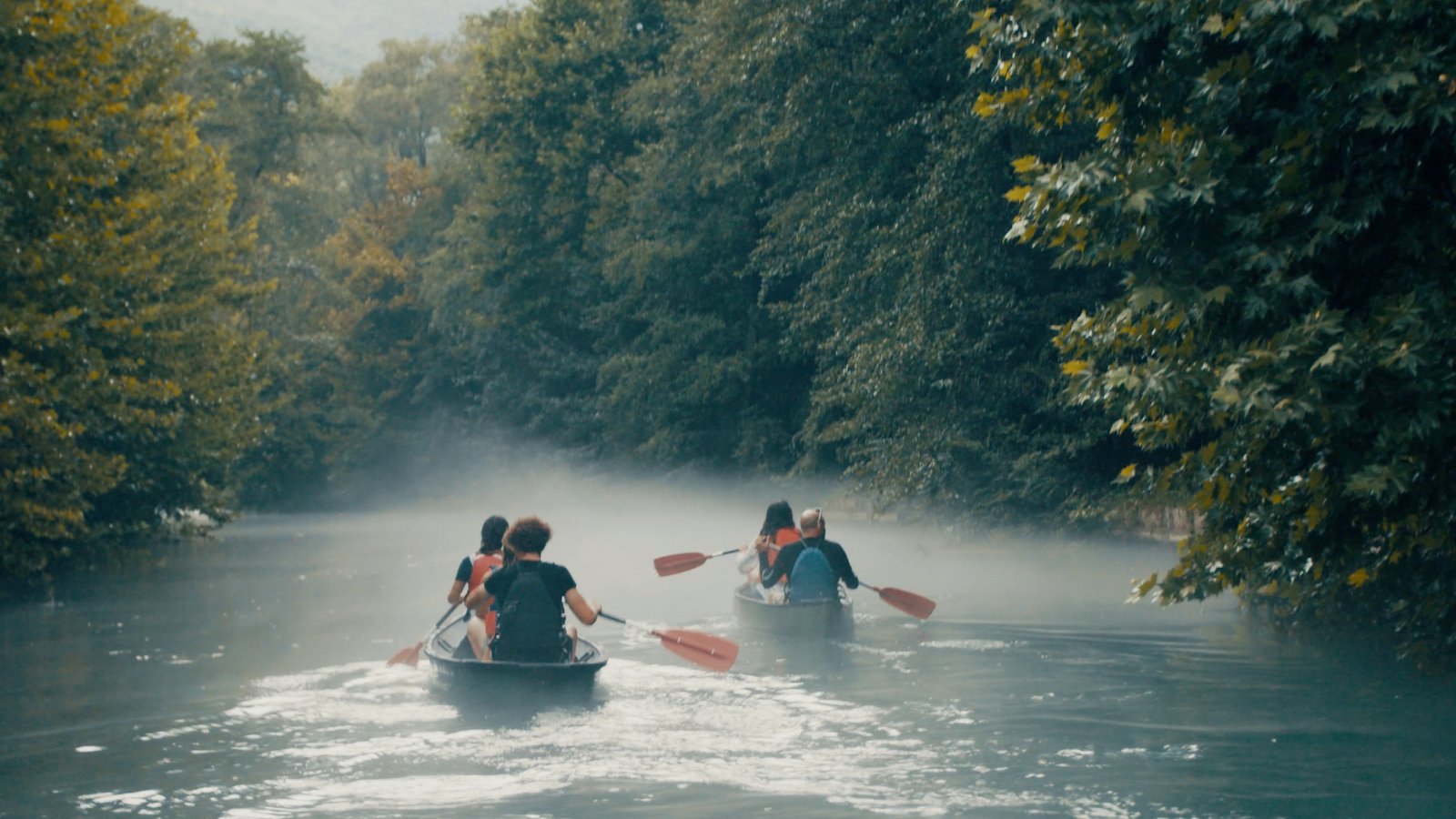 Voyageurs en canoë sur une rivière forestière